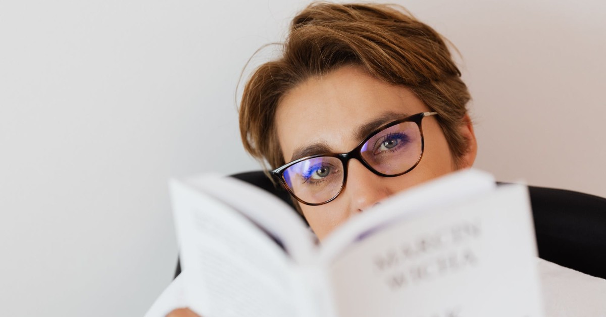 person in glasses reading a book
